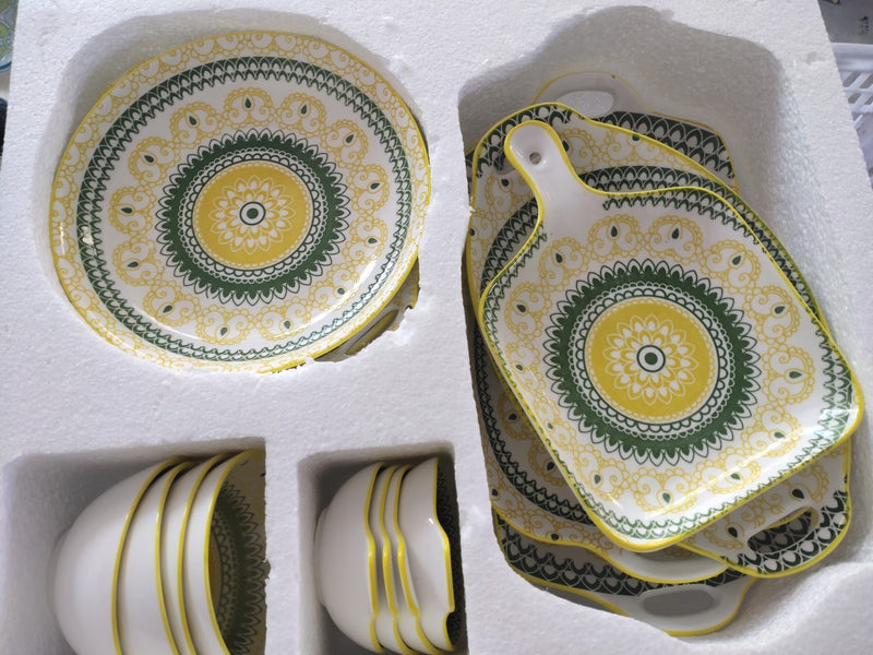 Conjunto de pratos e talheres de cerâmica boêmia em caixa colorida.