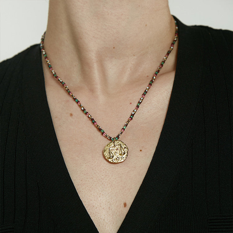 Perlenkette mit Goldmünzenmotiven und Motiven der zwölf Sternbilder