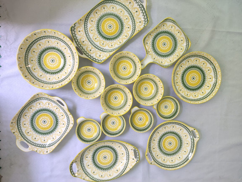 Conjunto de pratos e talheres de cerâmica boêmia em caixa colorida.