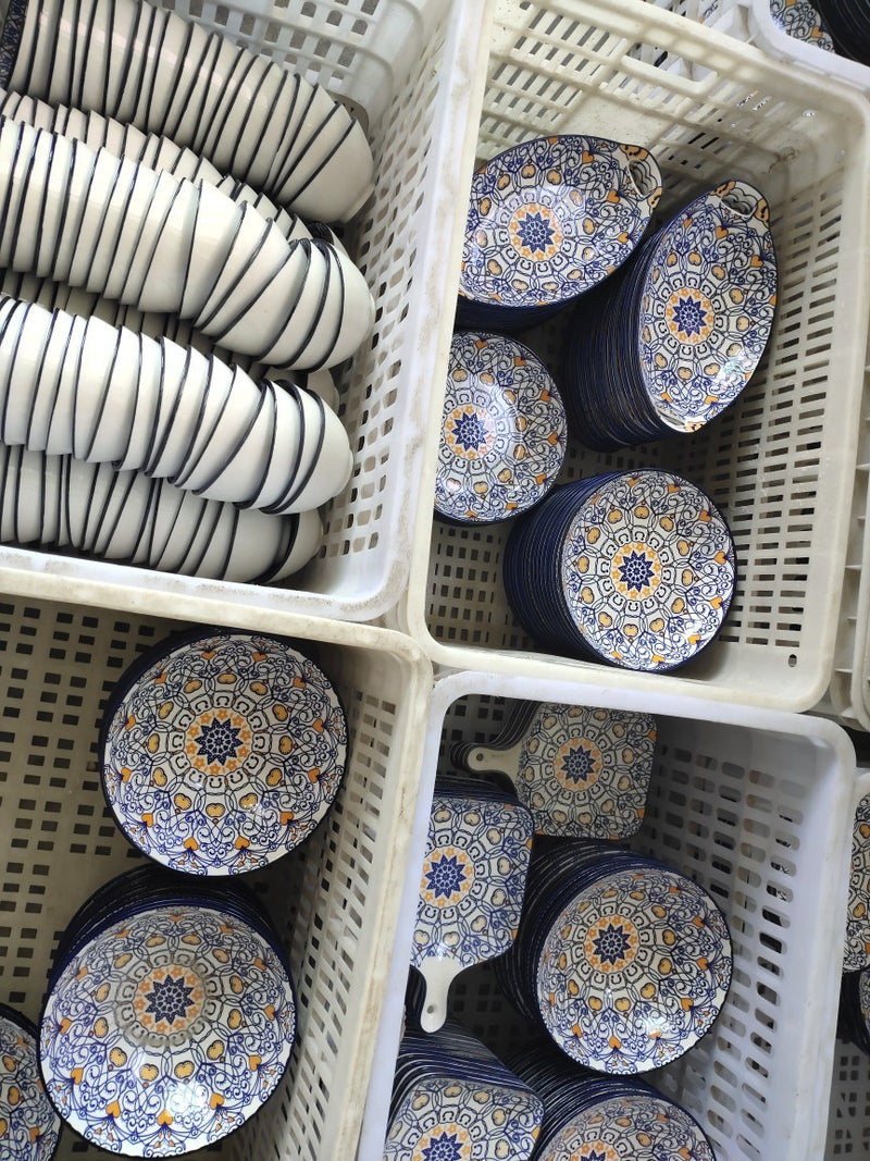 Conjunto de pratos e talheres de cerâmica boêmia em caixa colorida.
